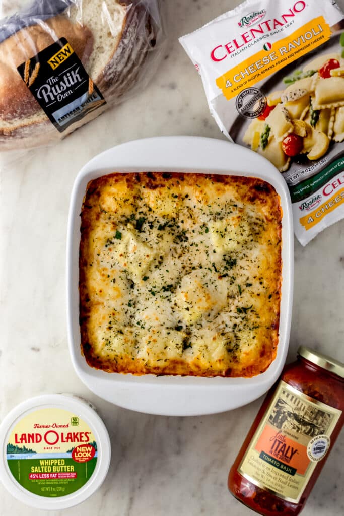 baked ravioli in baking dish with items to make the meal around it. 