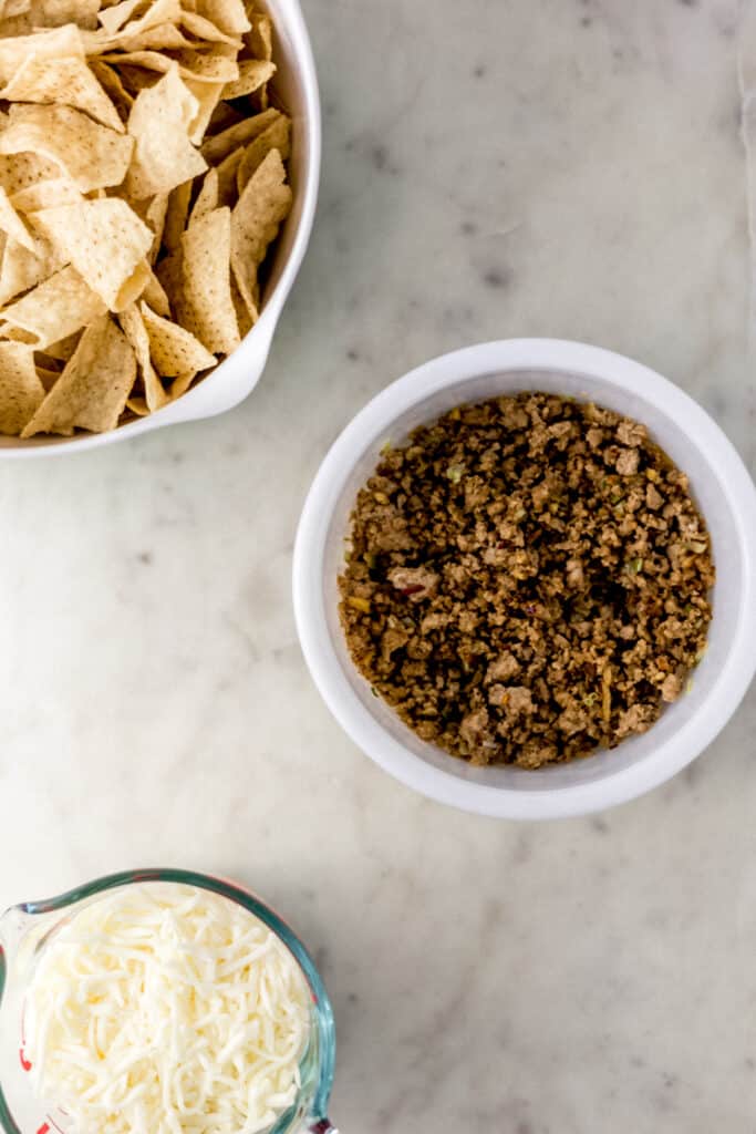 ingredients to make ground pork nachos in separate containers 