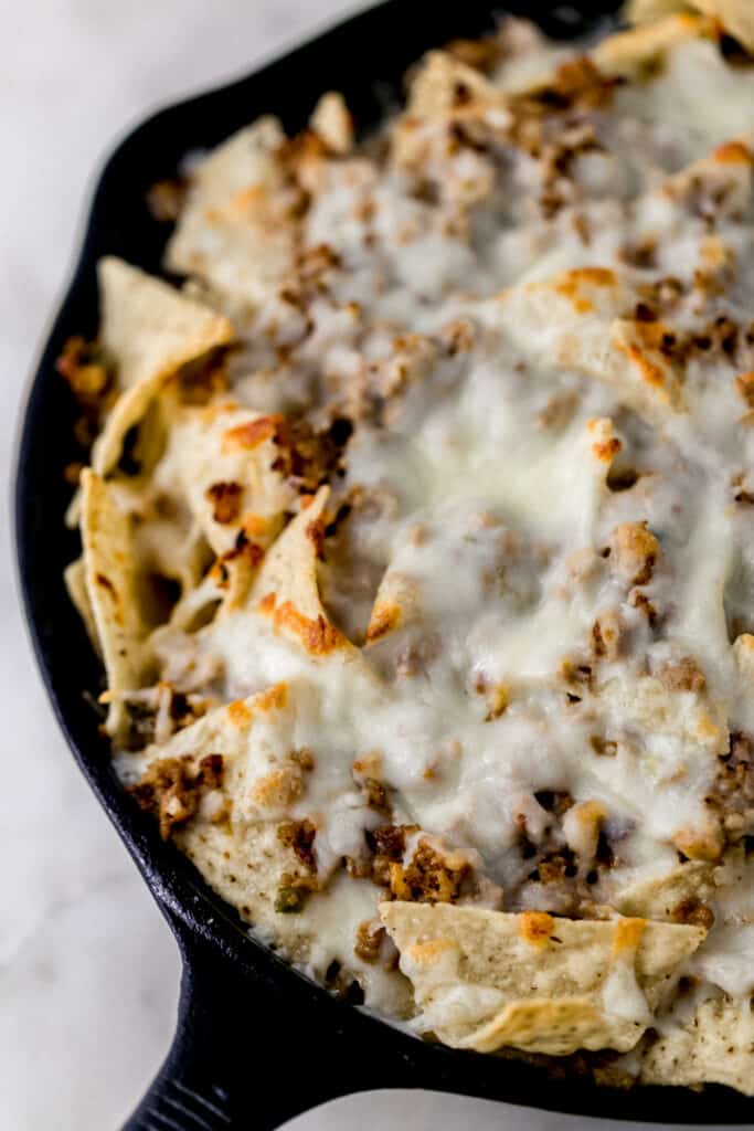 baked ground pork nachos in cast iron skillet