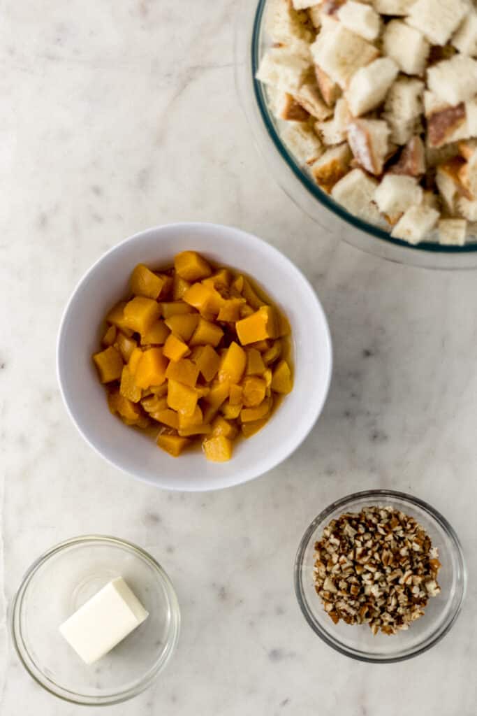 ingredients for peach bread pudding in separate small bowls