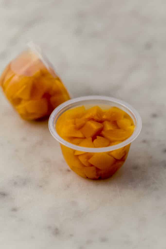 close up side view cling peaches in single serve container 