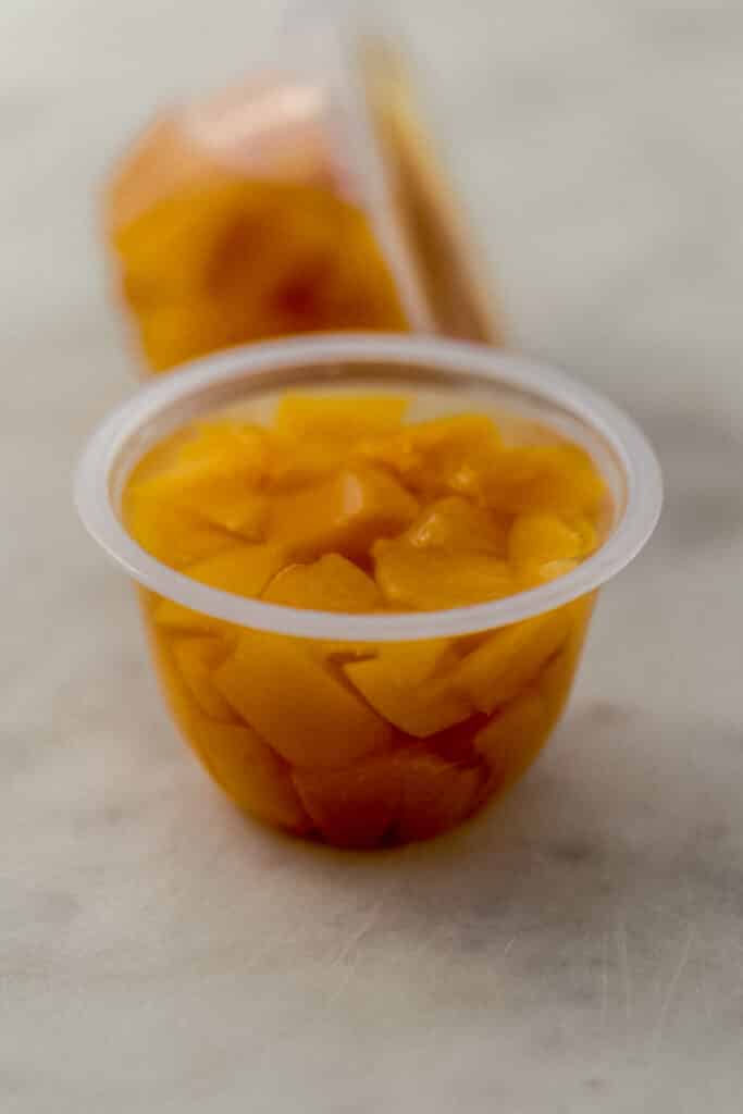 close up view diced cling peaches in container 