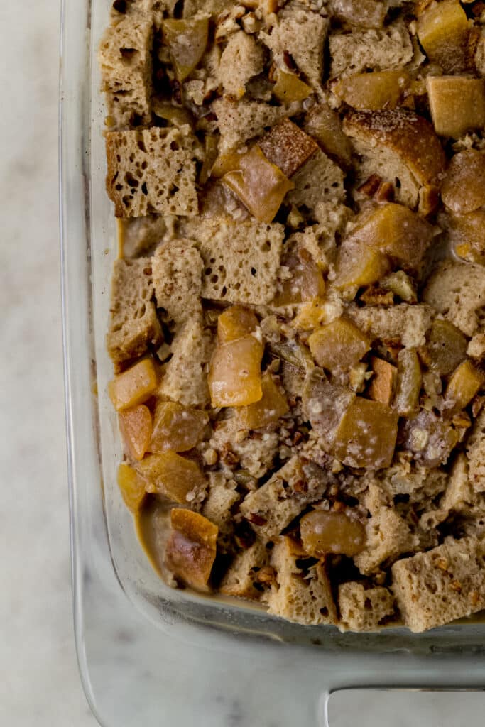 unbaked peach bread pudding in glass rectangle baking dish. 