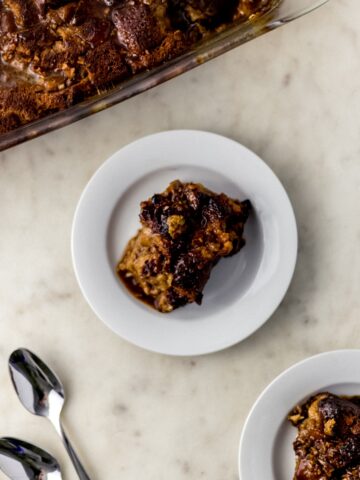 peach bread pudding in baking dish and on two white plates with spoons