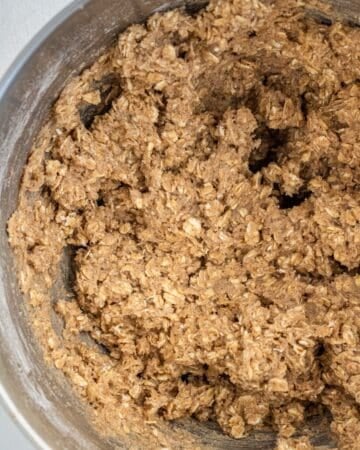 Oatmeal mixture added to butter mixture in stand mixer bowl.
