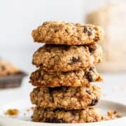 Close up side view of stacked cookies on white plate.