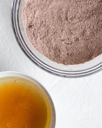 Two mixing bowls with wet and dry brownie ingredients.