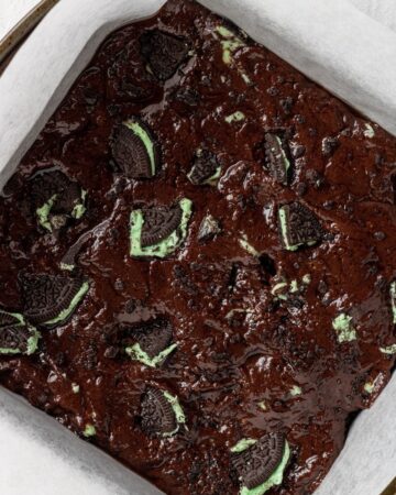 Brownie batter in parchment lined baking pan.