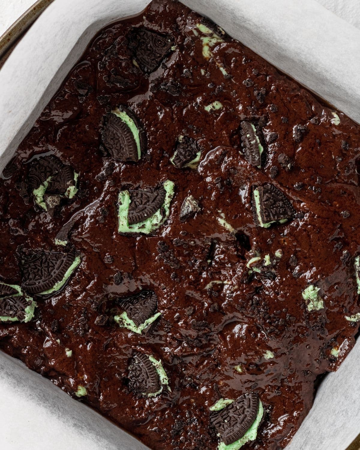 Brownie batter added to parchment lined baking pan.