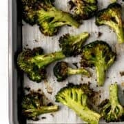 Overhead view of finished broccoli on parchment lined sheet pan.
