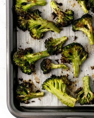 Overhead view of finished broccoli on parchment lined sheet pan.