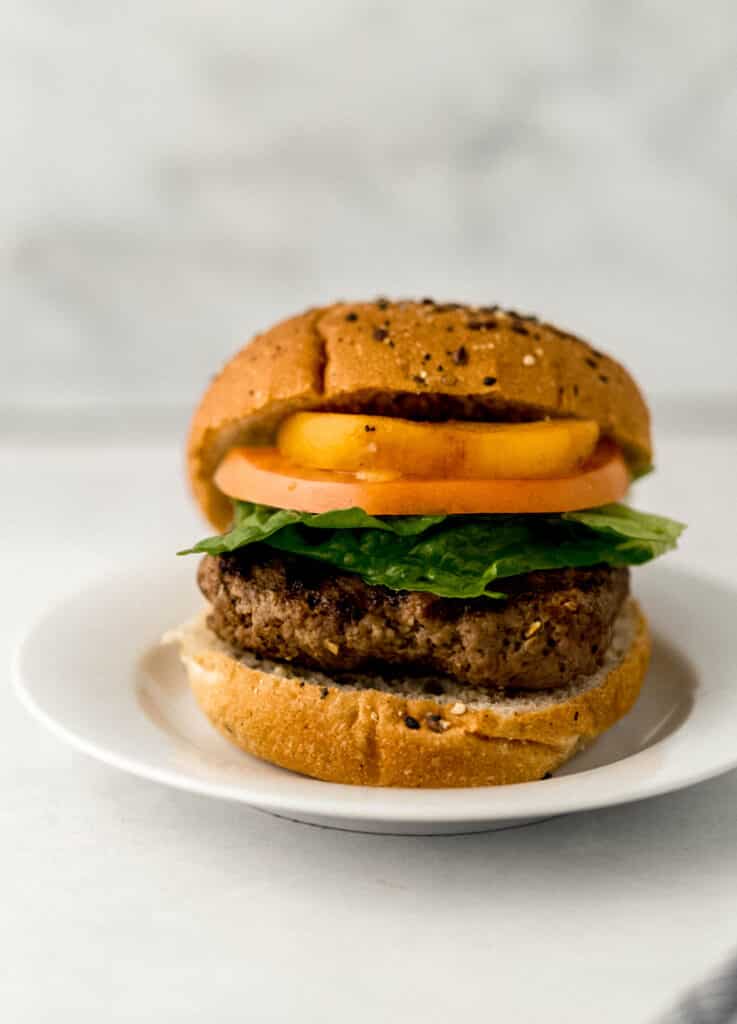 close up side view hamburger on white plate. 