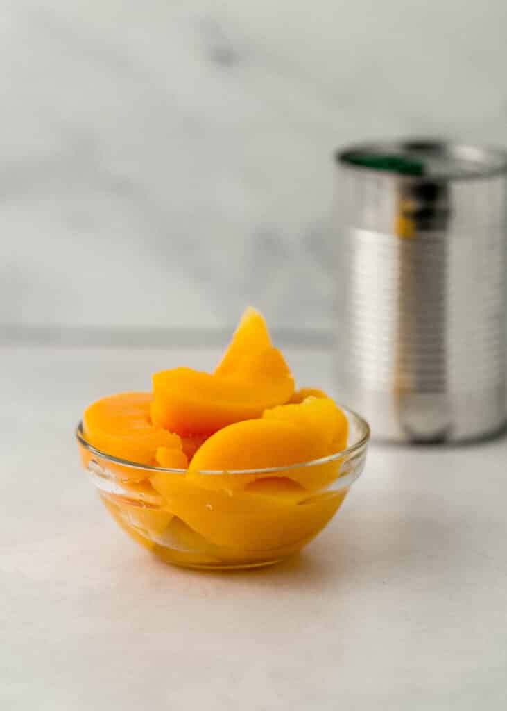 close up side view sliced peaches in small glass bowl 