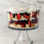 Close up side view of finished trifle topped with whipped topping.