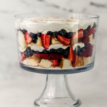 Close up side view of finished trifle topped with whipped topping.