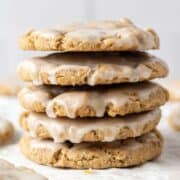 Close up side view of cookies stacked on parchment paper.