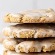 Close up side view of stacked cookies on parchment paper on pin with text overlay.