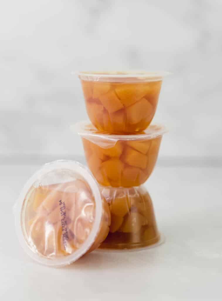 stack of single serve containers of diced peaches 