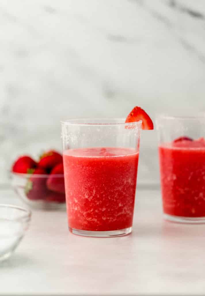 frozen margarita in glass with strawberry slice on the salted rim. 