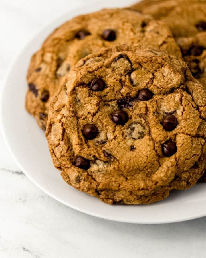 Close up view of white plate of cookies on marble surface.