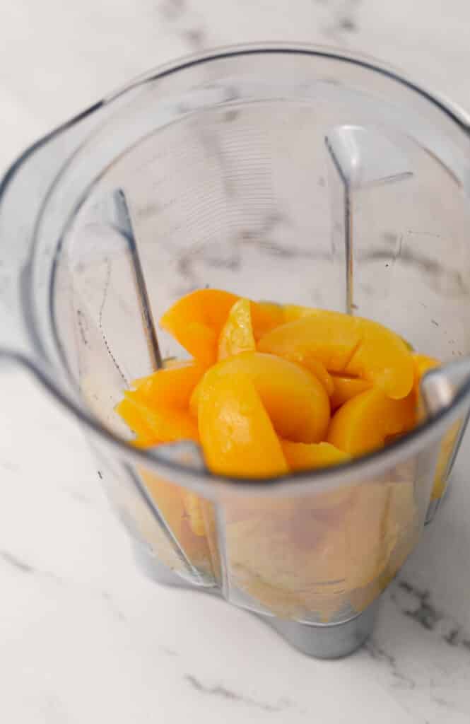 sliced peaches and honey in blender pitcher