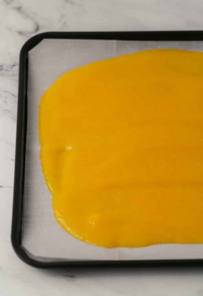 baking sheet lined with parchment paper topped with peach puree mixture 
