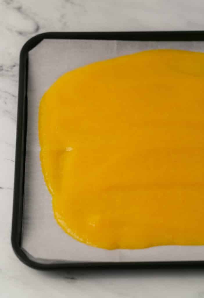 baking sheet lined with parchment paper topped with peach puree mixture