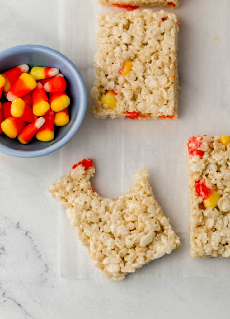 rice krispie treats and small blue bowl with candy corn in it. 