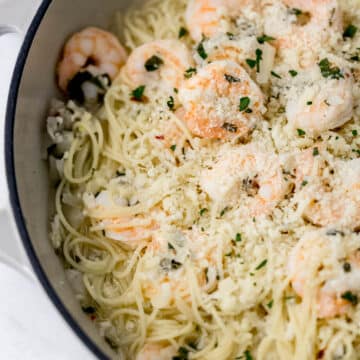 finished shrimp scampi in cast iron skillet topped with parmesan cheese