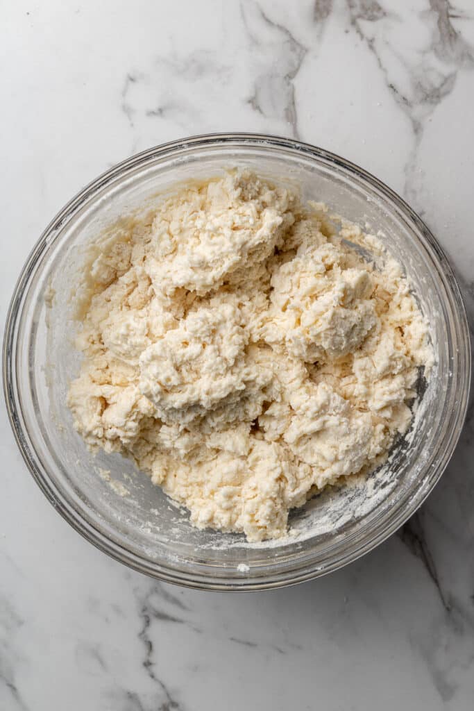 loose dough ball to make biscuits in large glass mixing bowl