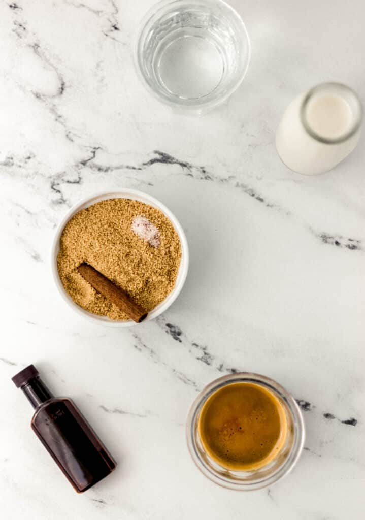 ingredients needed to make shaken espresso in separate containers on marble surface