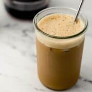 Close up of finished espresso in glass with straw.