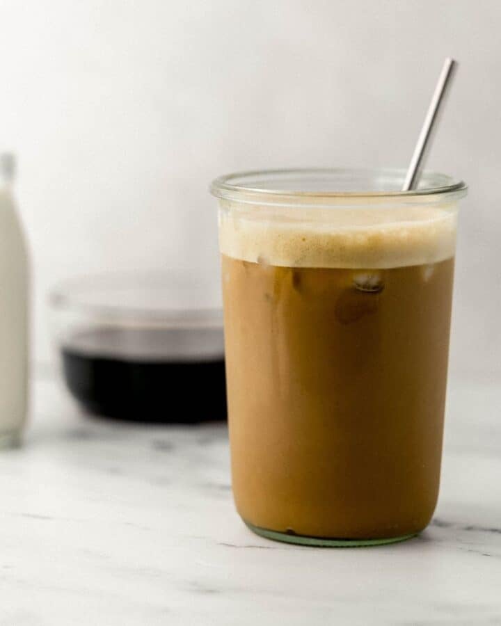 Side view of finished drink in glass with straw. 