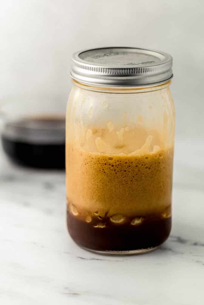 glass jar with shaken espresso ingredients combined in it. 