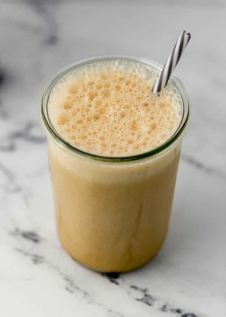 frappe in glass with straw on marble surface 