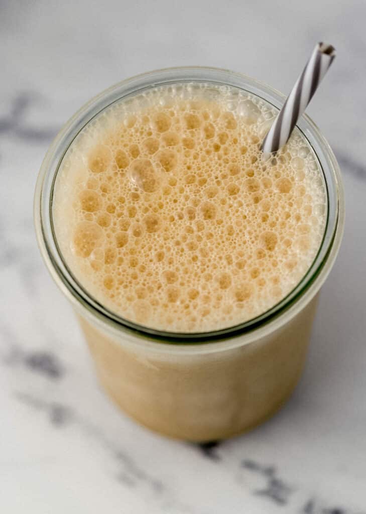 top of almond milk frappe in glass with straw 