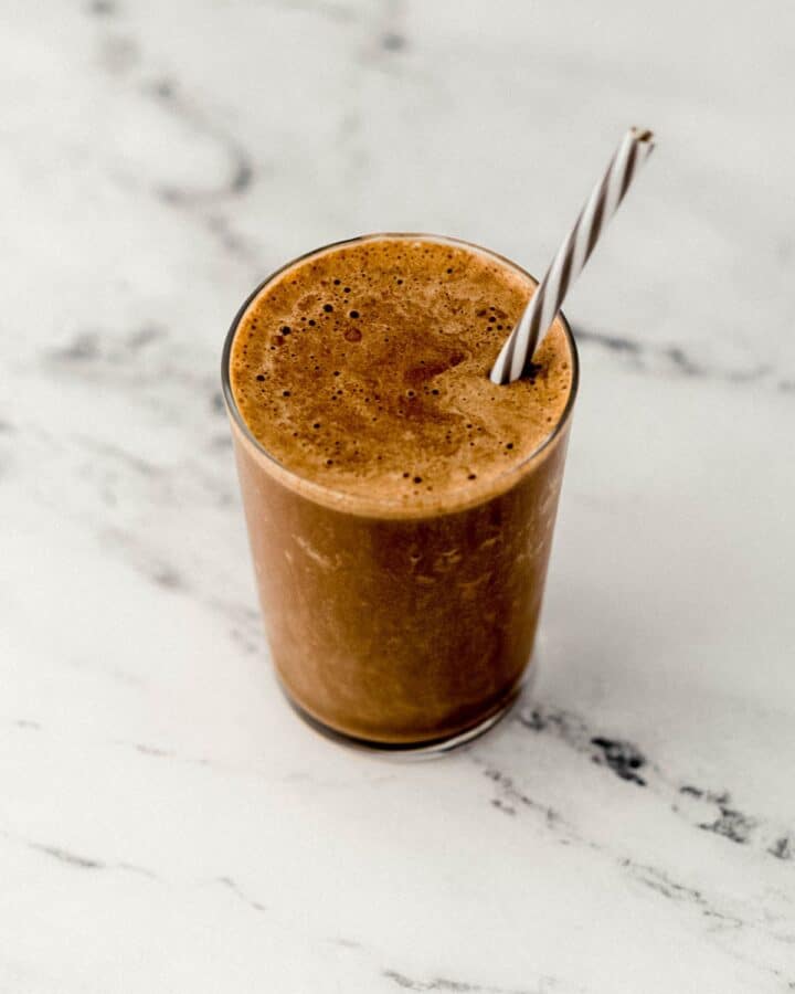 Finished smoothie in a glass with a straw. 