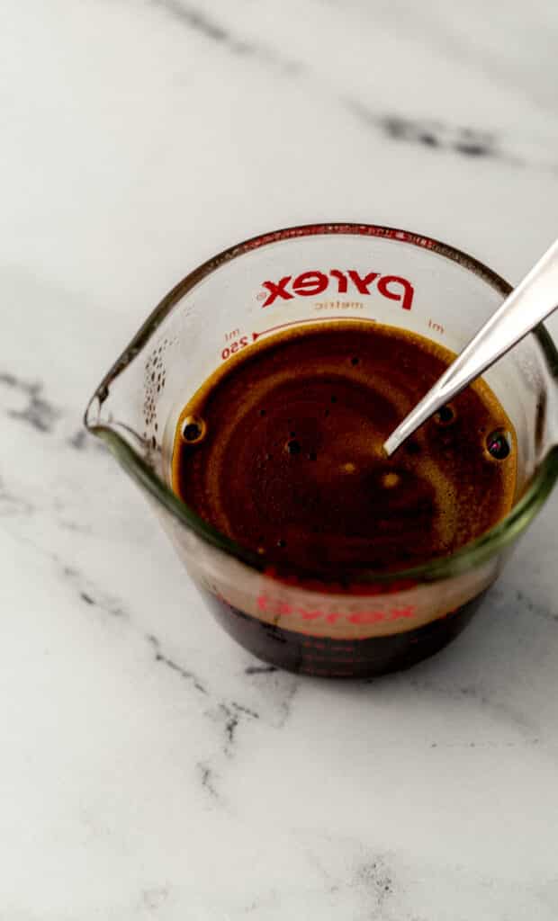 warm water mixed with instant espresso in small pyrex pitcher with spoon. 