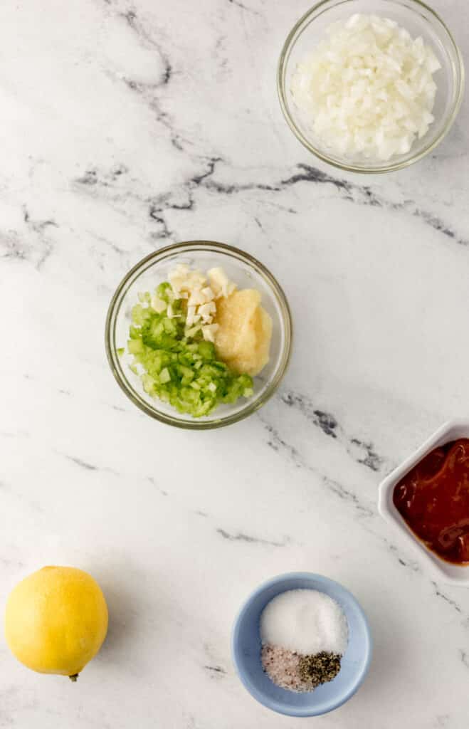 ingredients needed to make ginger dressing in separate containers on marble surface. 