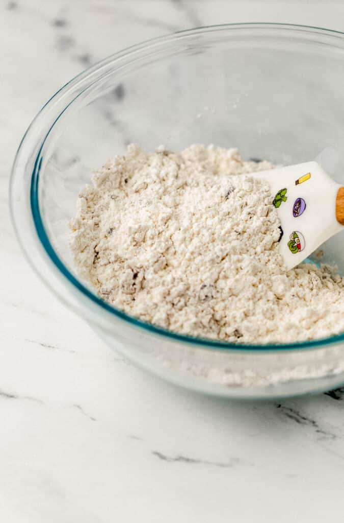 glass mixing bowl with dry ingredients and rubber spatula