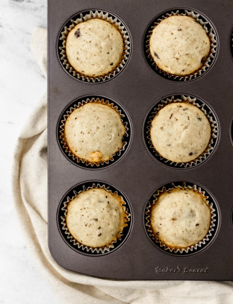 muffins finished baking in muffin pan with cloth napkin 
