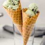 close up side view mint chocolate ice cream in two cones in glass