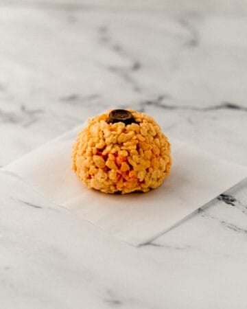 Chocolate rolo candy added to the top of a rice krispie treat ball.