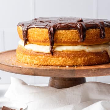 close up side view Boston cream cake on wooden cake stand with cloth napkin