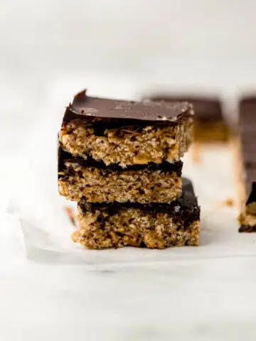 three chocolate almond butter crispy rice treats stacked on top of each other.