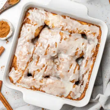 overhead view of cinnamon roll cake in a white square baking dish