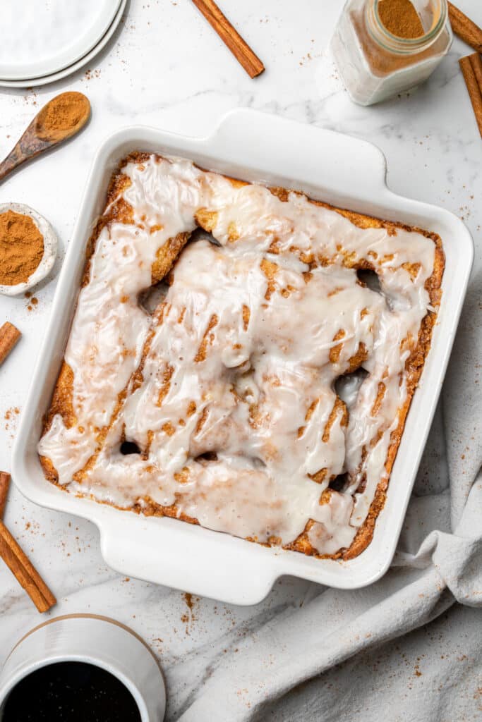 overhead view of a finished cinnamon roll cake in a white square baking dish.