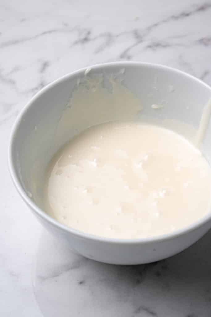 cake ingredients combined in white mixing bowl 