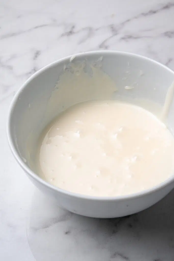cake ingredients combined in white mixing bowl 