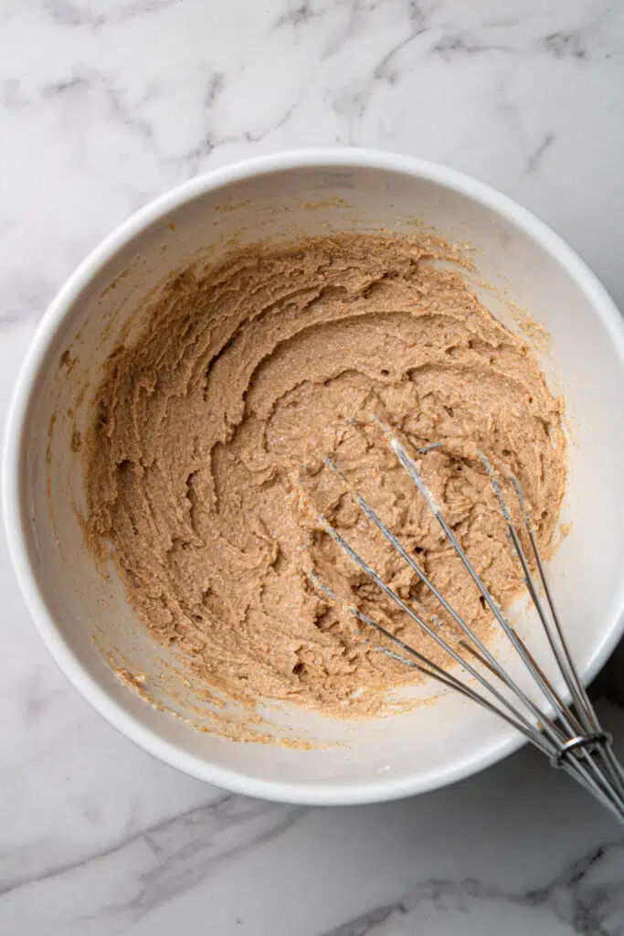 overhead view of cinnamon mixture in white mixing bowl with whisk 
